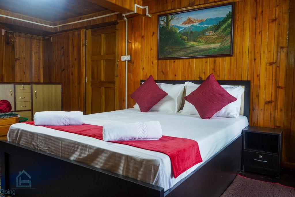a bedroom with a large bed with red pillows at Hidden Woods Homestay in Darjeeling