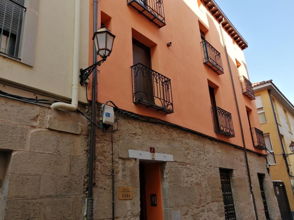 een oranje gebouw met balkons in een straat bij Casa MILA , Centro Histórico in Logroño