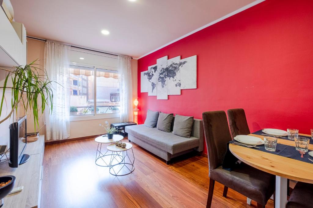 バルセロナにあるThree Bedroom Apartment in Santsの赤いリビングルーム(ソファ、テーブル付)
