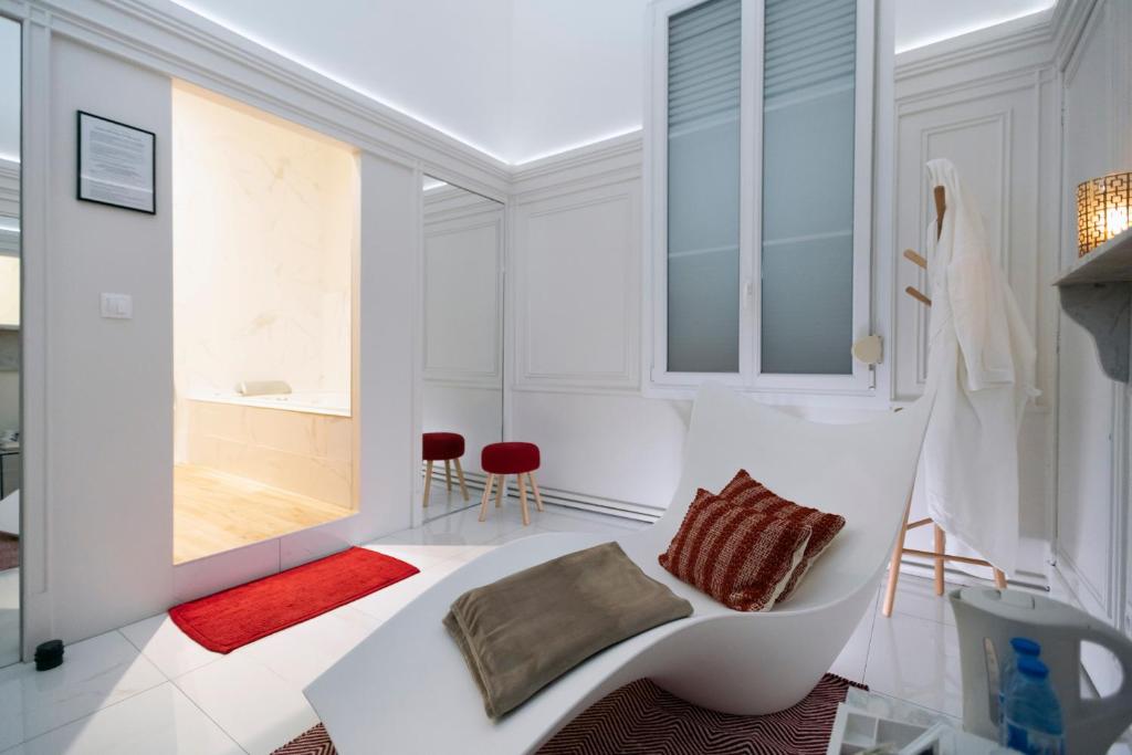 a white living room with a white couch and a window at La Demeure des Sacres - Cathédrale in Reims
