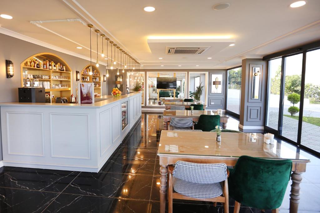 Şahin Tepesi Suite Otel في طرابزون: مطعم بطاولات وكراسي وبار