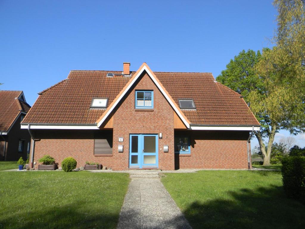 a red brick house with a blue door at Aquamarin in Dahme