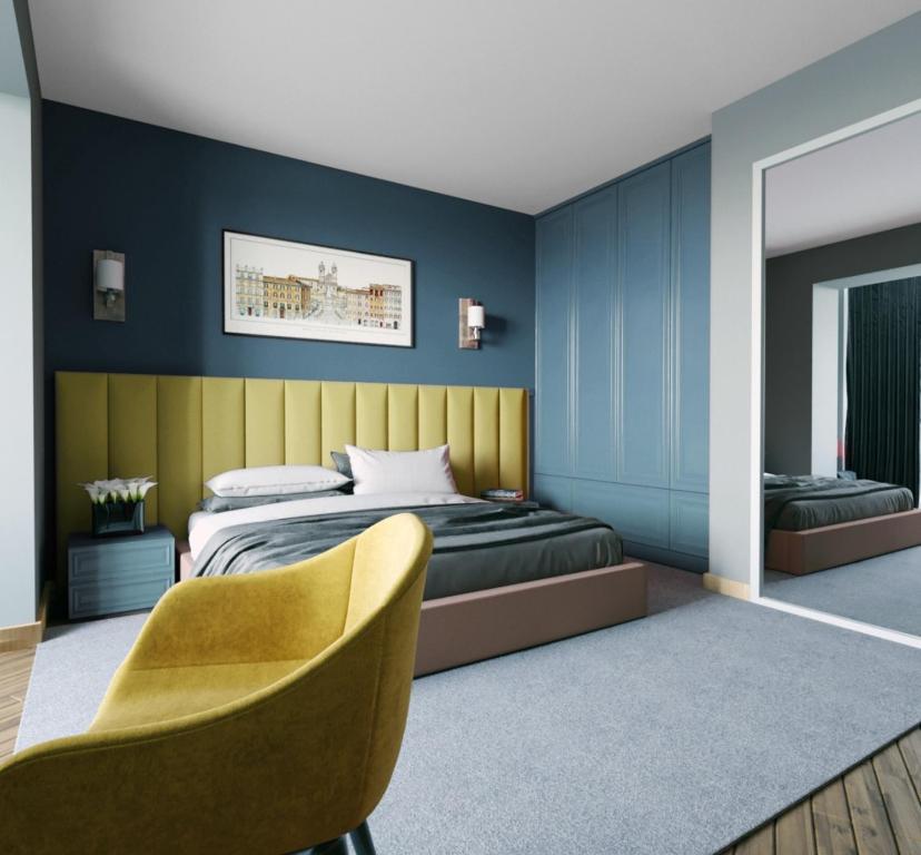 a bedroom with a bed and a yellow chair at Centric Baku Boutique Hotel in Baku