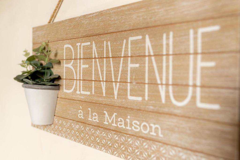 a wooden sign hanging on a wall with a plant at Las Casas de Doña Concha Mezquita in Córdoba