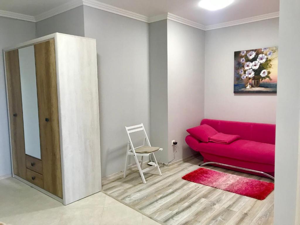 uma sala de estar com um sofá vermelho e uma cadeira em Роксолани 16 Апартаменти em Truskavets