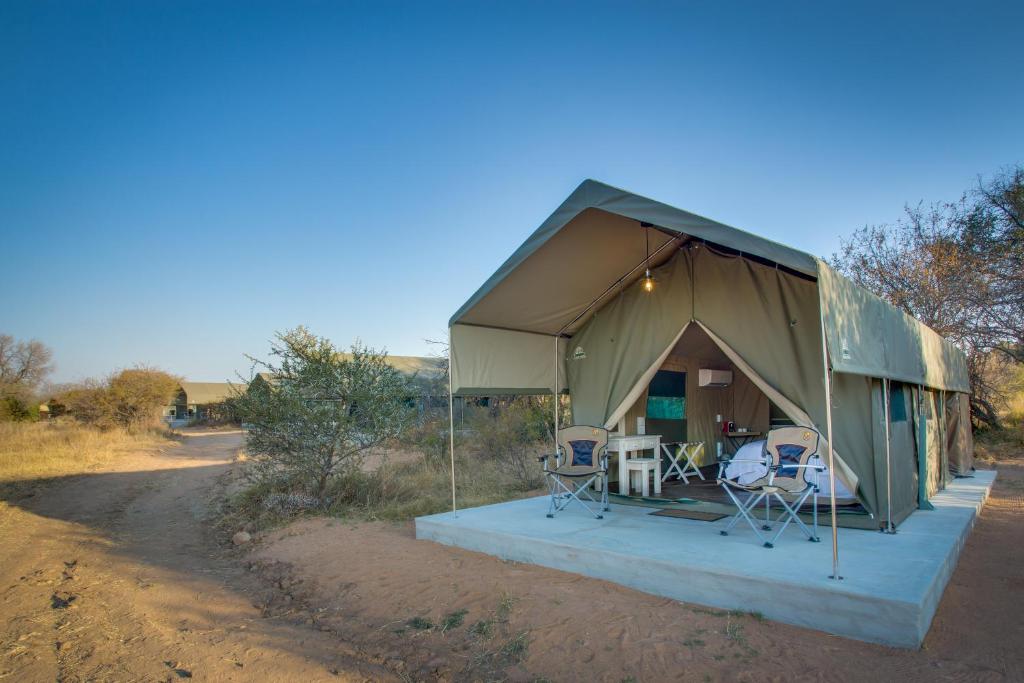 une grande tente verte avec des chaises et une table dans l'établissement Little Mongena Tented Camp, à Klipdrift
