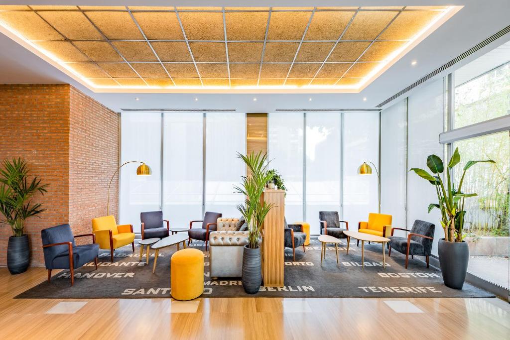 an office lobby with chairs and tables and windows at Hotel Madrid Chamartín, Affiliated by Meliá in Madrid