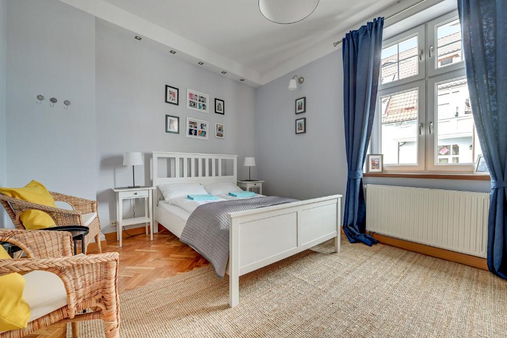 - une chambre avec un lit et une fenêtre avec des rideaux bleus dans l'établissement Grand Apartments - Brooklyn 2 bedroom apartment, à Sopot