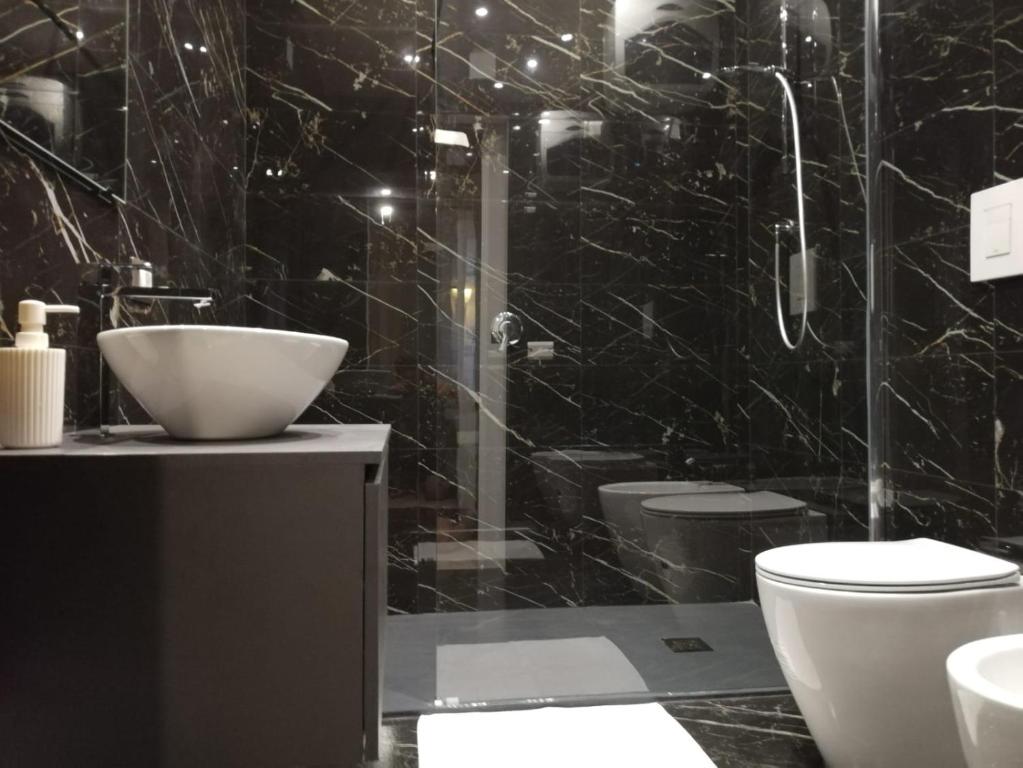 een zwarte badkamer met een wastafel en een toilet bij Sant Efisio Host in Cagliari