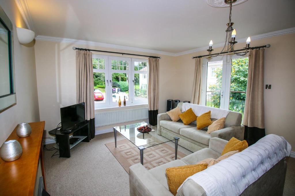 a living room with two couches and a tv at Turnberry Apartments in Turnberry