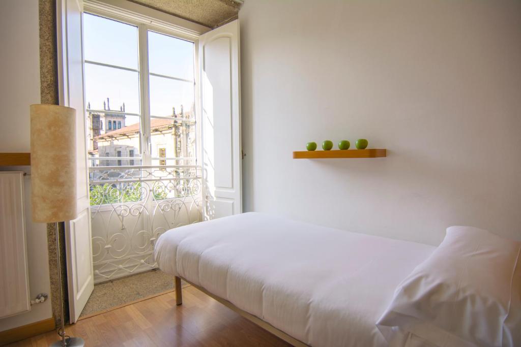 a bedroom with a bed and a large window at Libredón Rooms in Santiago de Compostela
