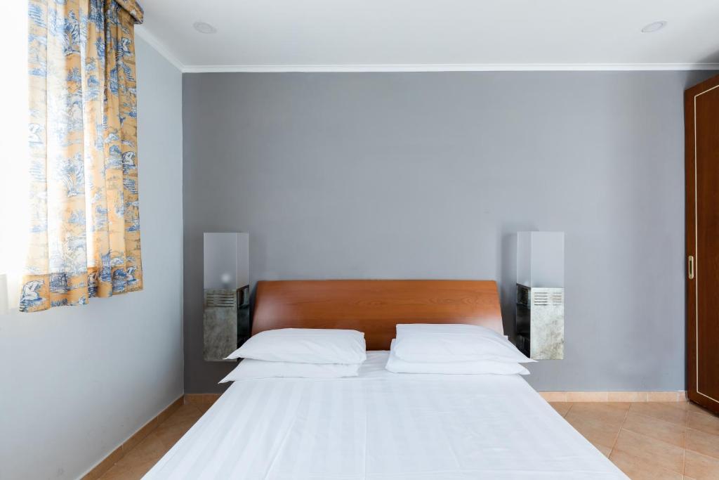 łóżko z 2 białymi poduszkami w sypialni w obiekcie Crosti Apartments w Rzymie
