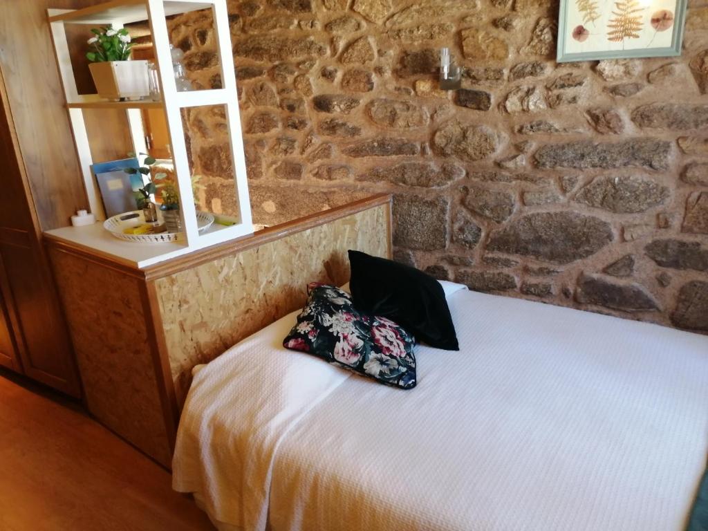 um quarto com uma cama com uma almofada em Casa do Forno em Almeida