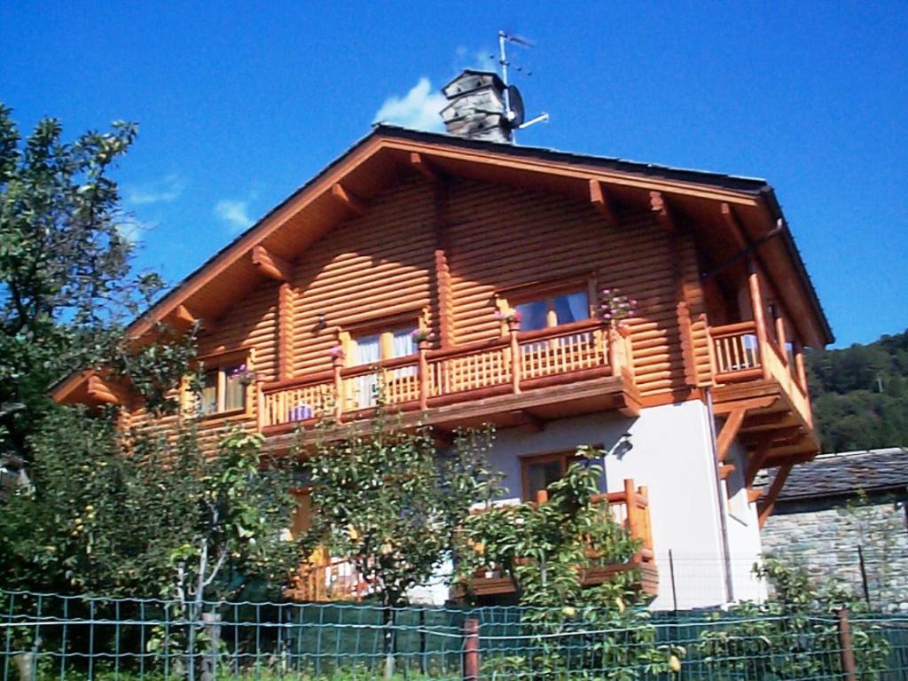 ein Holzhaus mit Balkon darüber in der Unterkunft Casa Moron in Saint Vincent