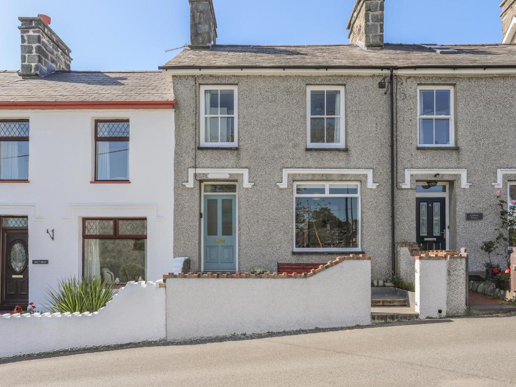 una casa con una cerca blanca delante de ella en Maes-Yr-Haf en Criccieth