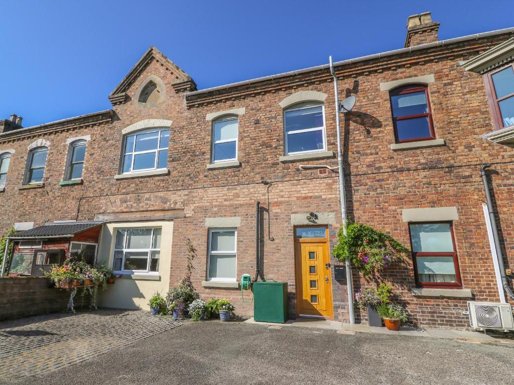 an old brick building with a yellow door at Ty'r Orsaf in Builth Wells