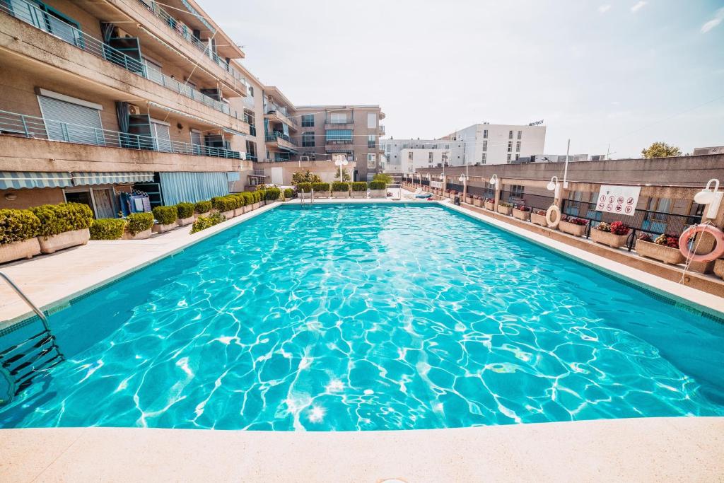 una piscina en un edificio con agua azul en Apartamento Salvis Terraza, en Platja d'Aro