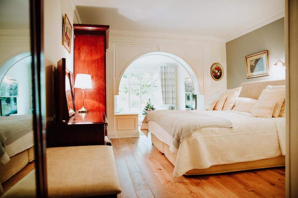 a bedroom with a large bed and an arched window at Cashel House Hotel in Roundstone