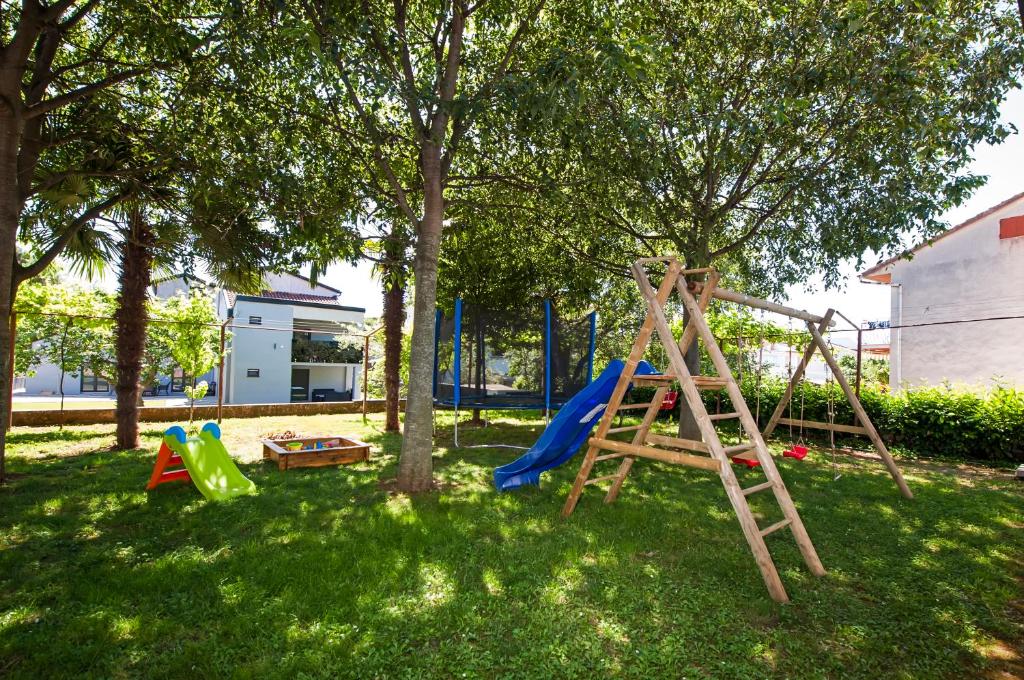plac zabaw z drzewem i huśtawką w obiekcie Apartments Modrušan w Rovinj