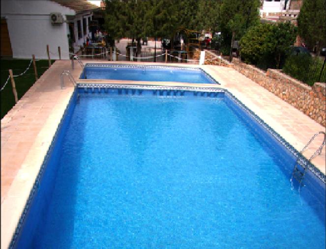 a large swimming pool with blue water at Hotel Matias in Ruidera