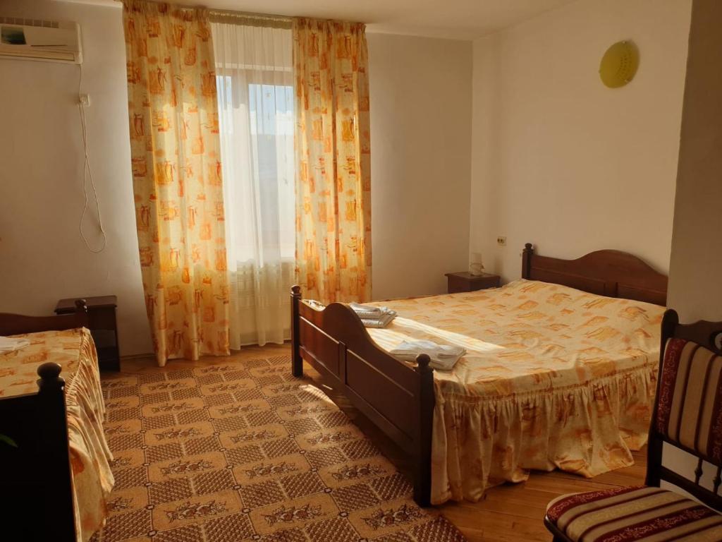 a bedroom with a large bed and a window at Motel Balcost in Piatra Neamţ