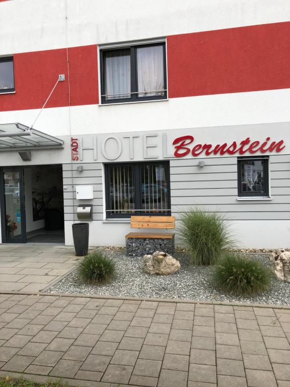 ein Hotelgebäude mit einer Bank davor in der Unterkunft Stadthotel Bernstein in Regensburg