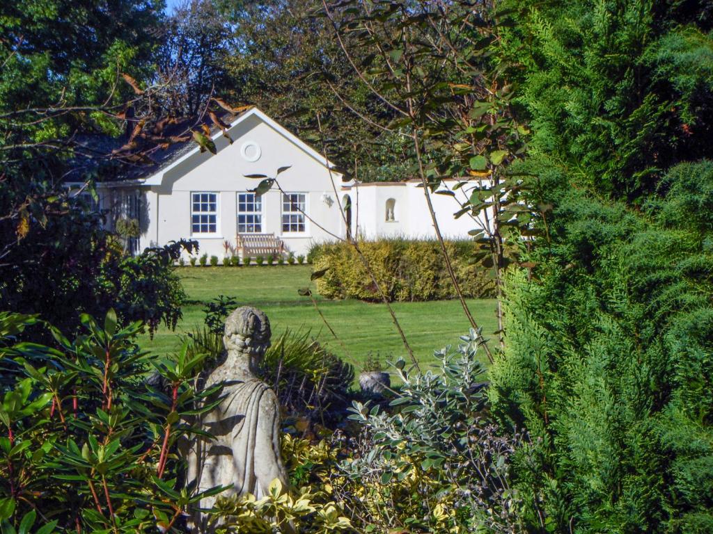 a statue in front of a white house at Charlton Lodge in Mawnan