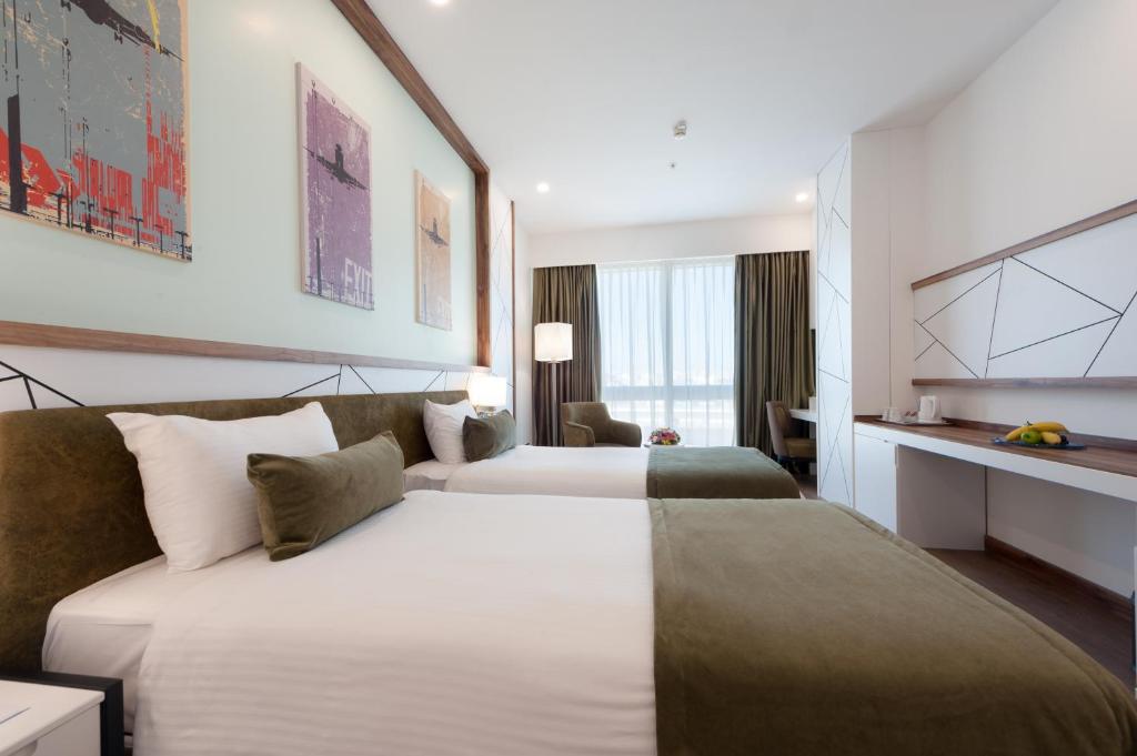 a hotel room with two beds and a desk at ISG Sabiha Gökçen Airport Hotel in Istanbul