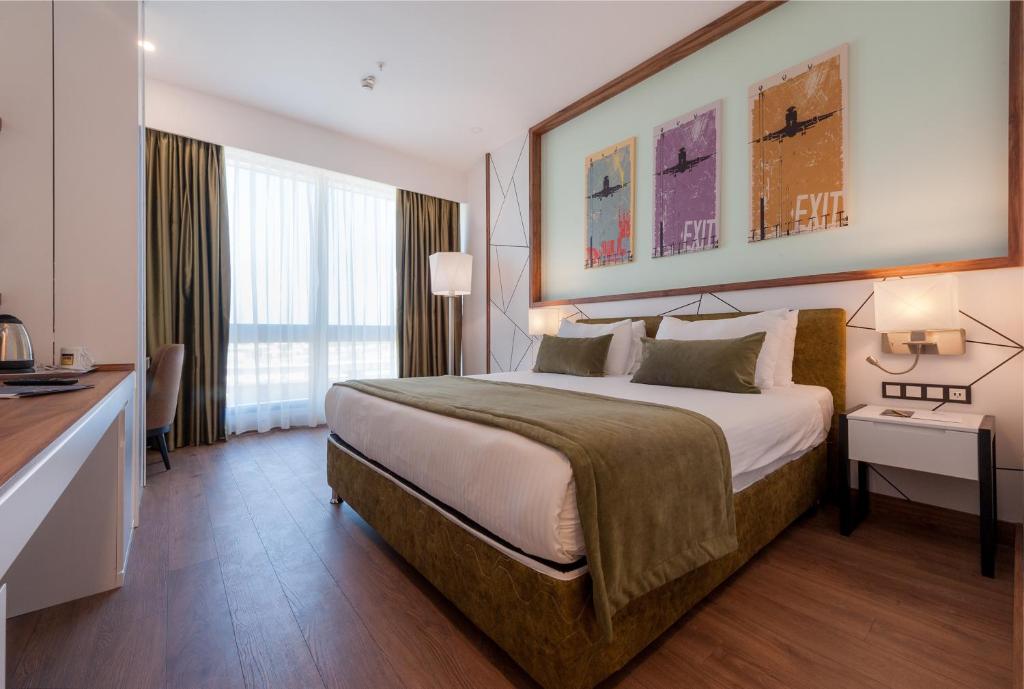 
a bedroom with a large bed and a large window at ISG Sabiha Gökçen Airport Hotel in Istanbul
