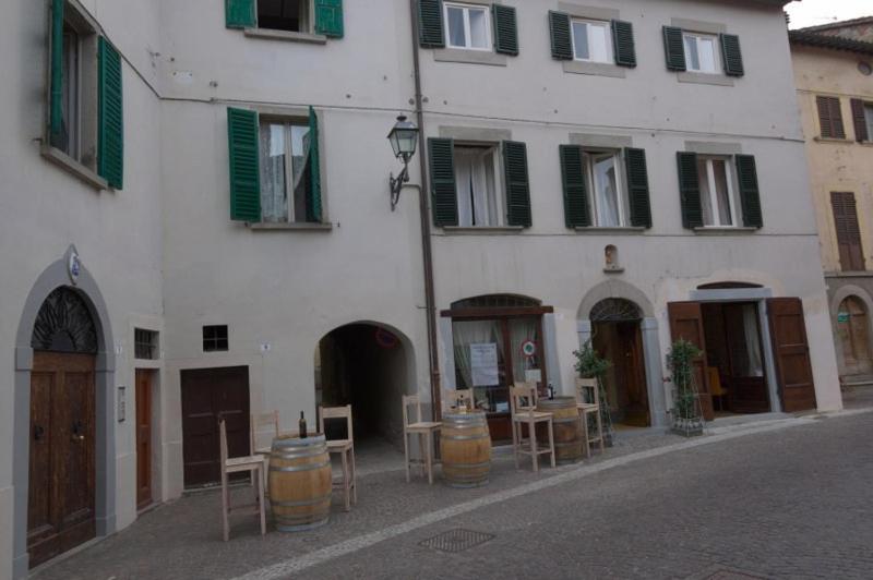 ein Gebäude mit Tischen und Stühlen davor in der Unterkunft Locanda Guelfo in Tredozio