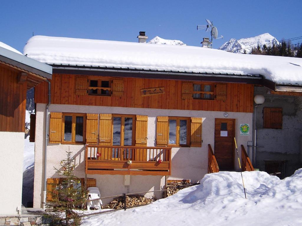 uma casa com neve no telhado em Chalet les Gentianes em Les Coches