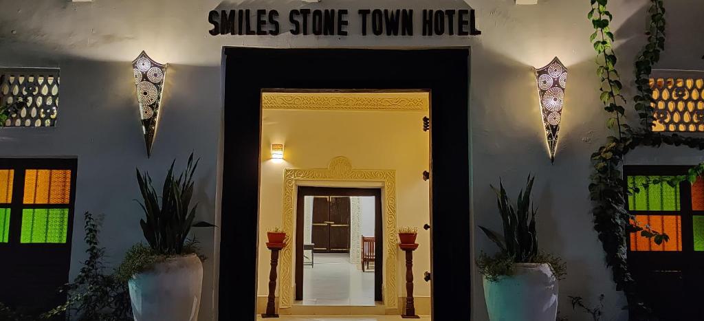 een hal met een deur en een bord met zijde in een herenhuis bij Smiles Stone Town Hotel in Zanzibar City