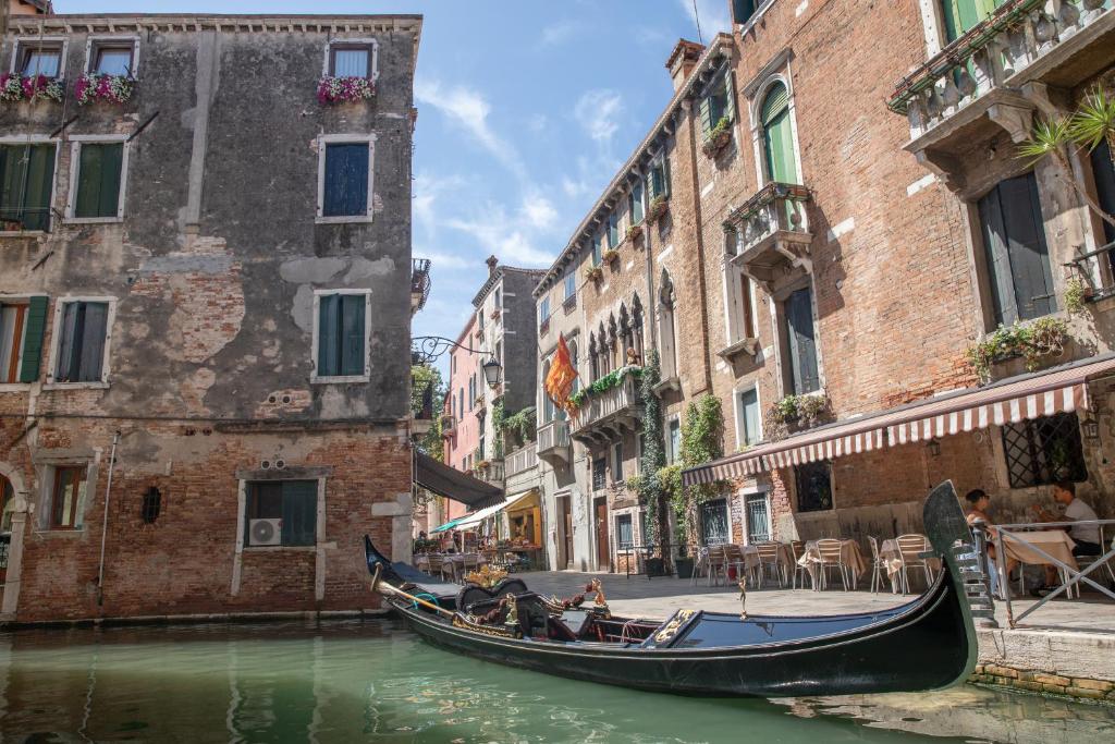 a gondola in a canal between two buildings at Dimora Al Doge Beato vista canale in Venice