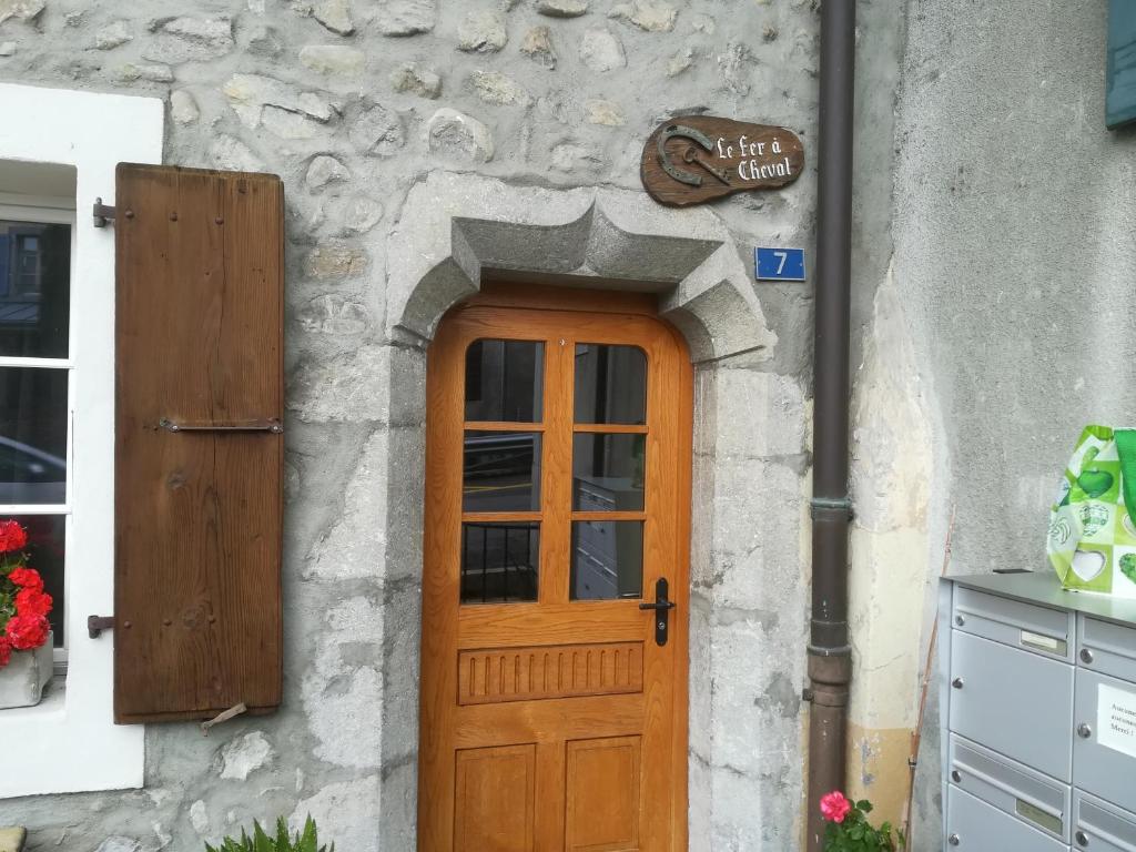 a door to a building with a stone wall at Le fer à cheval in Montreux