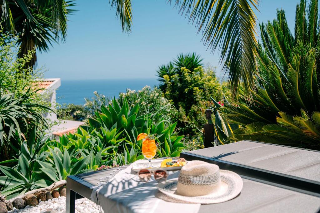 a table with a hat and a plate of food on it at Casas Serenas in Estreito da Calheta