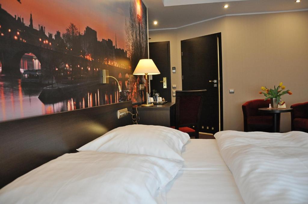 a hotel room with a bed and a painting on the wall at Hotel Atrium in Nowy Tomyśl