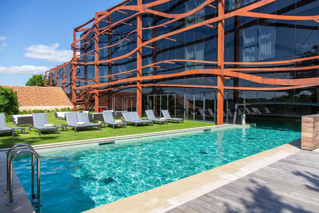 a swimming pool in front of a building at Hôtel Chais Monnet & Spa in Cognac