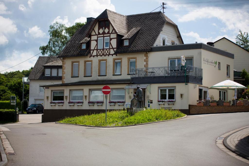 une grande maison avec un panneau d'arrêt devant elle dans l'établissement Hotel Waldfrieden, à Emmelshausen