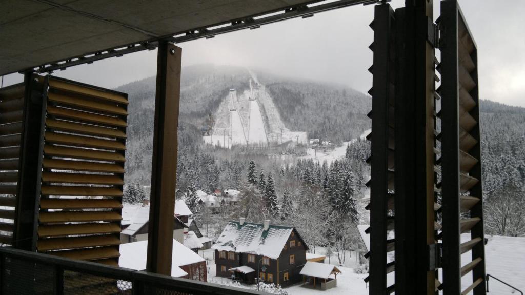 Blick auf eine Skihütte aus dem Fenster in der Unterkunft Apartmány Čertovka in Harrachov