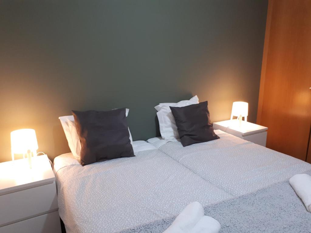 ein Schlafzimmer mit einem großen Bett mit zwei Nachttischen in der Unterkunft Coimbra Holiday Residence in Coimbra