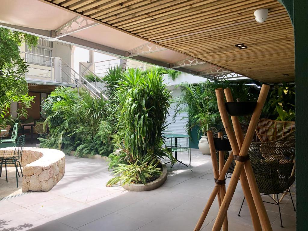 a patio with plants and a table and chairs at Centr'Hotel in Marigot