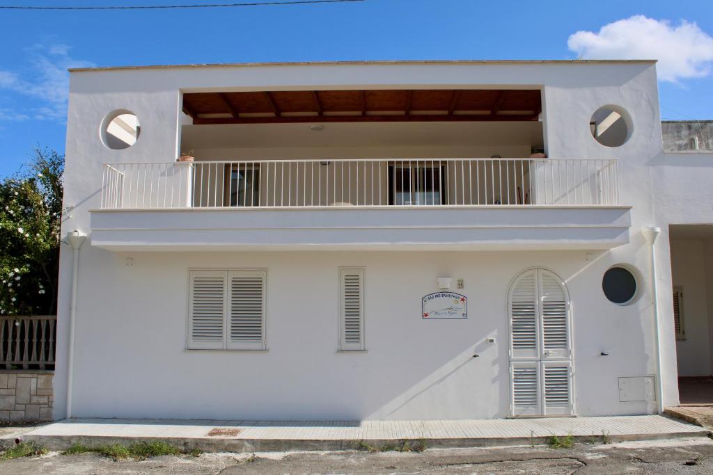 a white house with a balcony at B&B Mare di Ricordi Camera in San Foca