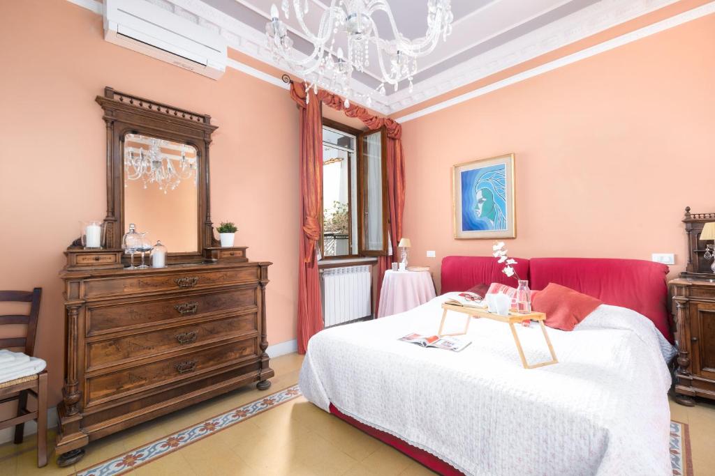 a bedroom with a red bed and a dresser at Villino Simona in Viareggio