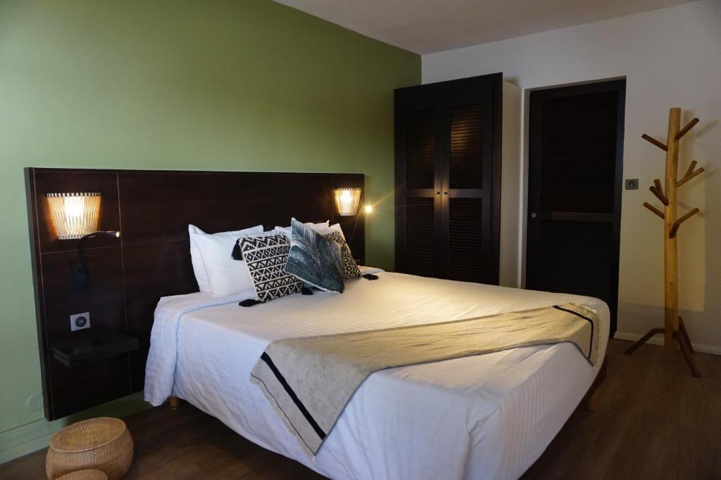 a bedroom with a large bed with white sheets and pillows at Centr'Hotel in Marigot