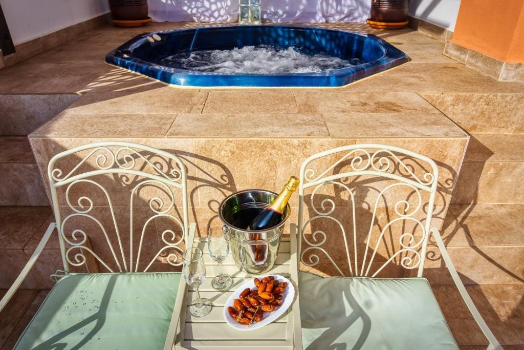 een schaal noten en een glas wijn op een tafel met een bad bij Apartamento DESA Laguna Beach Vera Playa in Vera