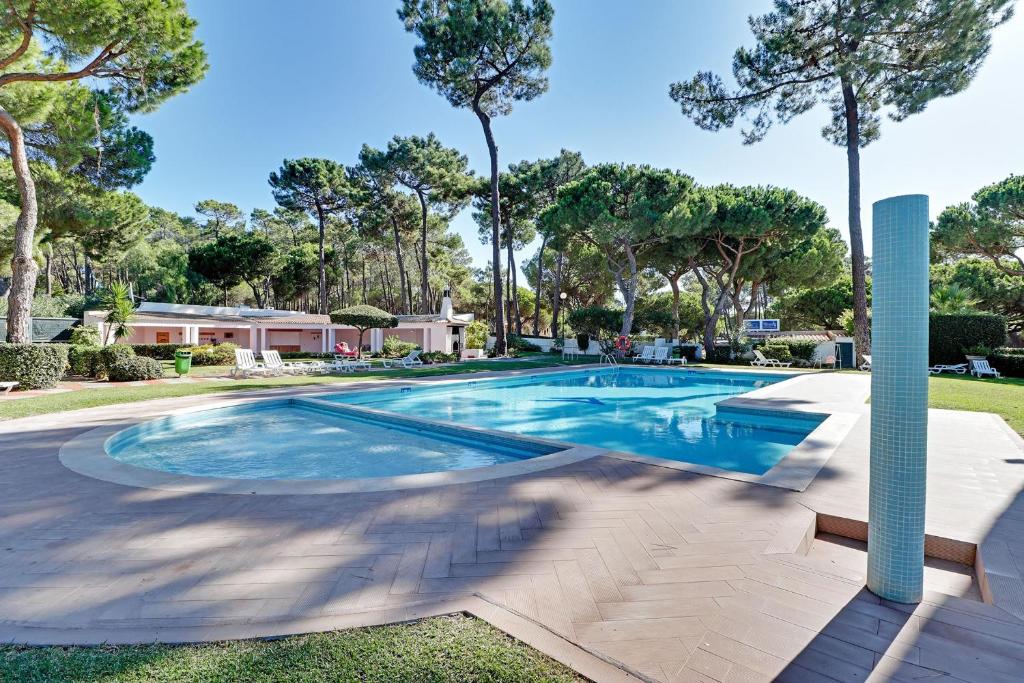a swimming pool in a yard with trees at Vilamoura Golf Villa 1 by Homing in Vilamoura