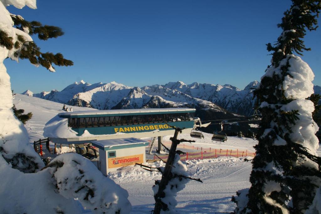 un lodge de ski avec une montagne enneigée en arrière-plan dans l'établissement Ferienhaus Fanningberg, à Weisspriach