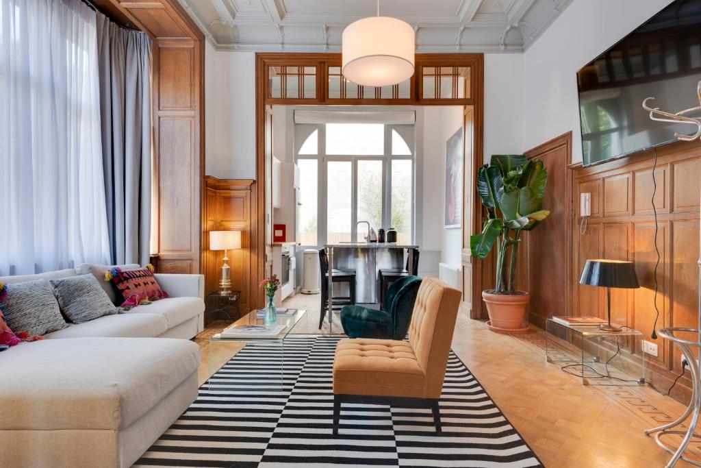 ein Wohnzimmer mit einem Sofa und einem Tisch in der Unterkunft Newton Boutique Hotel Residences - Brussels EU Area in Brüssel