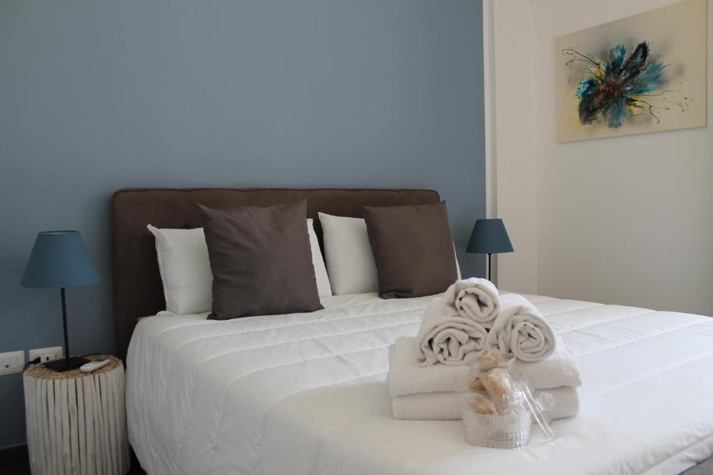 a bedroom with a white bed with towels on it at Residence Pola in Catania
