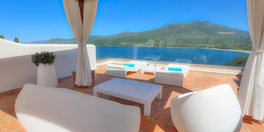 a balcony with white chairs and a view of the water at Miramar Corsica in Propriano